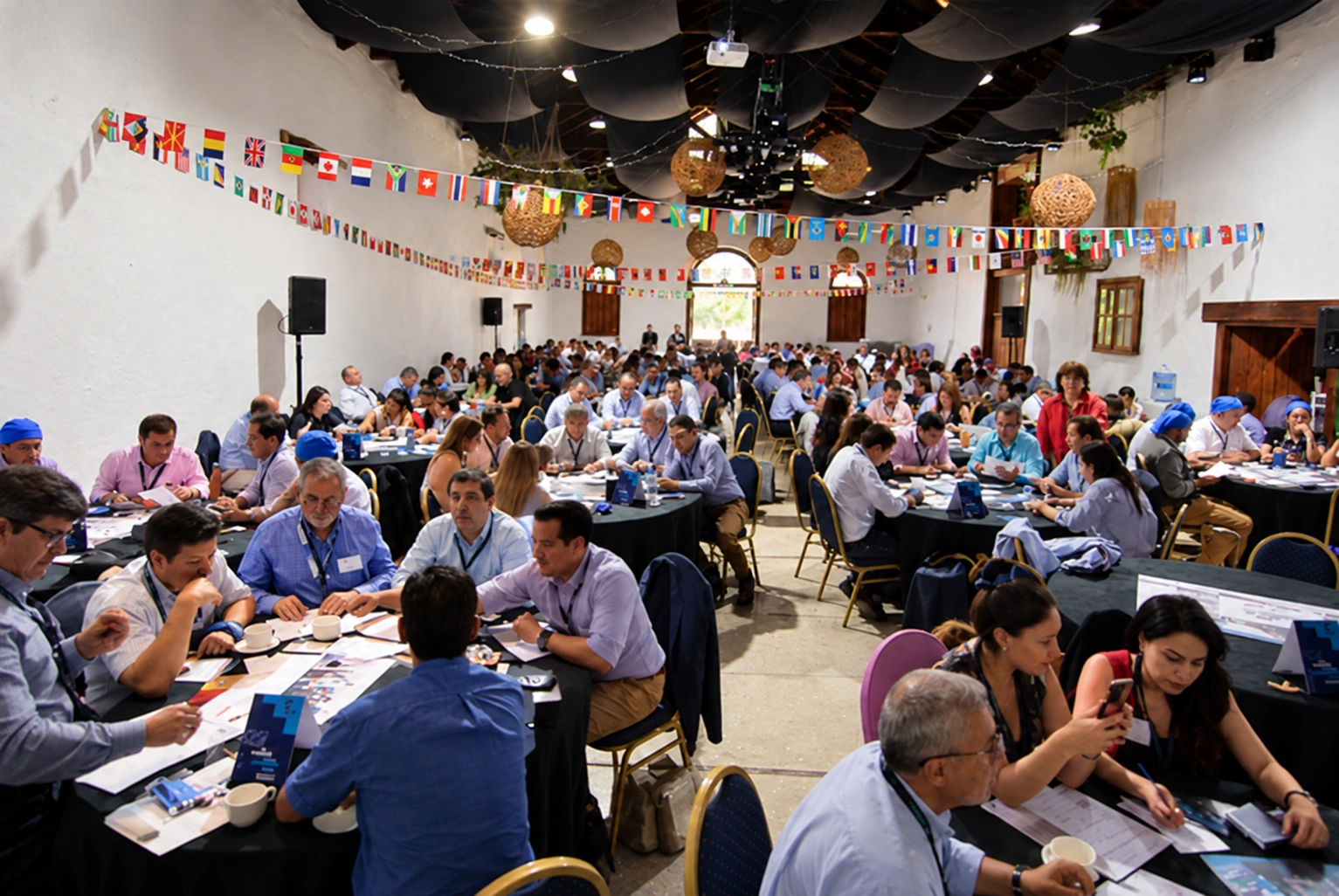 Grupo de participantes colaborando en mesas durante una actividad de equipo